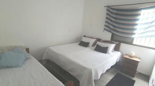 a small room with two beds and a window at casa com piscina da edi fontes in Guarujá