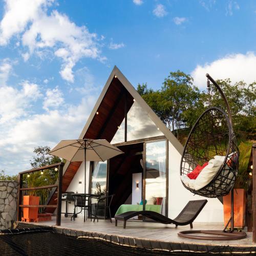 a house with two swings next to a pool at Glamping Pedro in San Gil