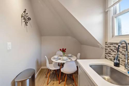 Una cocina con una mesa y sillas y un fregadero. en King Bed | WiFi Desk | Air Hockey | Car Bed, en East Orange