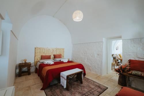 a bedroom with a bed with a red bedspread at i Trulli di Figazzano in Locorotondo