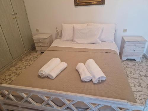 Una cama con dos almohadas y dos toallas encima. en Alexandros Home, en Perdika