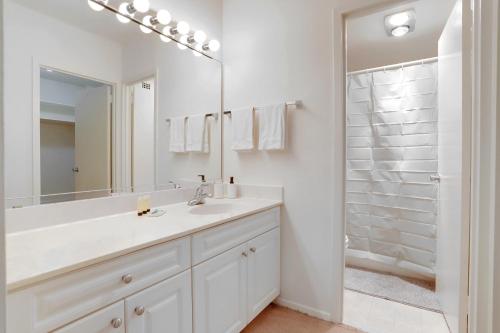 a white bathroom with a sink and a shower at Spacius Apt W Excellent Amenities in Arlington