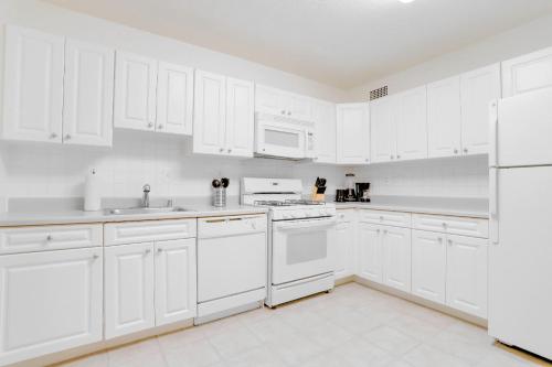 a white kitchen with white appliances and white cabinets at Spacius Apt W Excellent Amenities in Arlington
