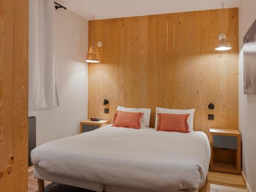 - une chambre avec un grand lit blanc et deux oreillers orange dans l'établissement Appartement rénové proche pistes, terrasse spacieuse - FR-1-808-21, à La Salle Les Alpes