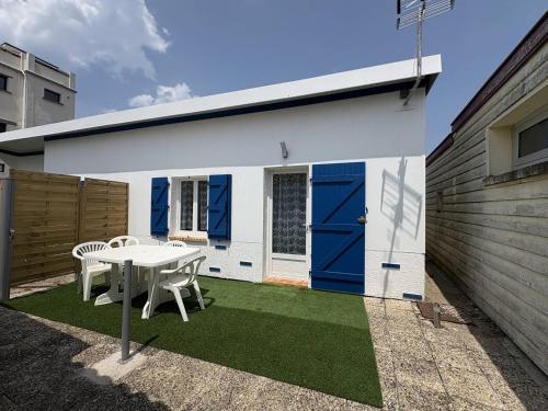 une maison avec une table et une porte bleue dans l'établissement Ombre et Vague, à Mimizan-Plage