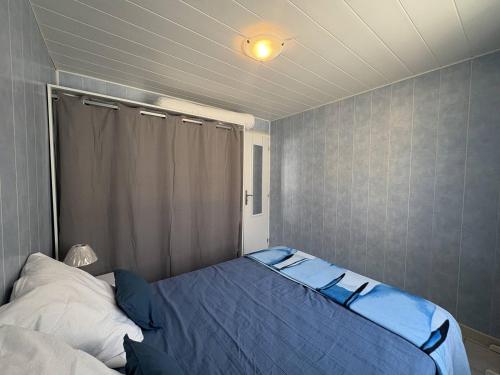 une chambre avec un lit avec une couverture bleue dans l'établissement Ombre et Vague, à Mimizan-Plage