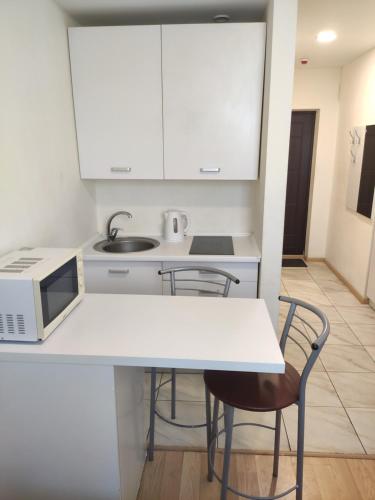 a kitchen with a white table and chairs and a microwave at Smart House on Mashynobudivna in Kyiv
