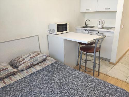 a small room with a bed and a counter with a microwave at Smart House on Mashynobudivna in Kyiv