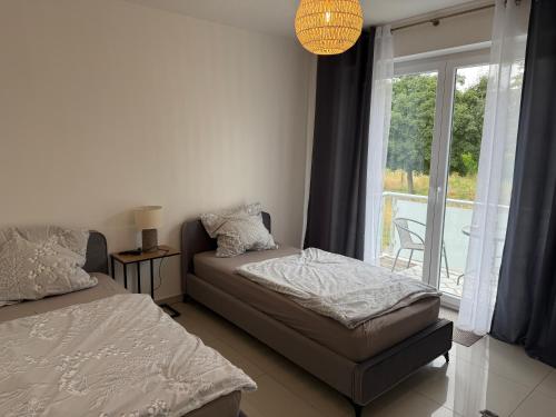 a bedroom with two beds and a large window at Stilvolles Appartment in Paderborn
