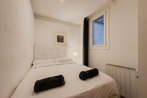 a bedroom with a bed with two black pillows on it at Casa en Barcelona in Barcelona
