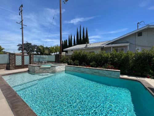 フラートンにあるBeautiful Remodel 3 Bedroom 2 bathroom Home with Pool & Jacuzziの庭の青い水のスイミングプール