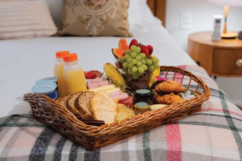 a basket of bread and fruit on a bed at Vila Manaca Da Serra in Canela