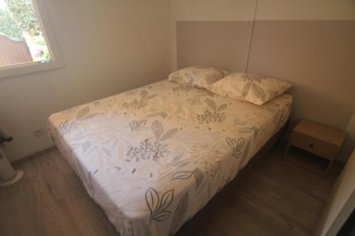 a small bedroom with a bed with a white comforter at la brise marine in Plage dʼArgelès