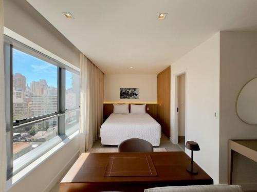 a bedroom with a bed and a large window at Apto completo em Pinheiros. Estilo e Conforto! in Sao Paulo