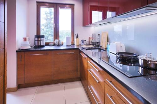 a kitchen with wooden cabinets and a counter top at Apartament Chopina Premium in Suwałki