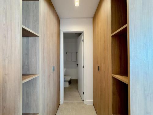 a hallway with wooden cabinets and a toilet in a bathroom at Apto completo em Pinheiros. Estilo e Conforto! in Sao Paulo