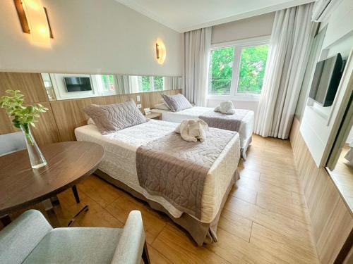 a hotel room with two beds with a dog laying on the bed at Nadai Confort Hotel e Spa in Foz do Iguaçu