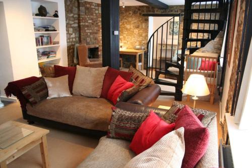 a living room with a couch with pillows at Stylish 4Bed Cottage with parking near town and beach in Lyme Regis