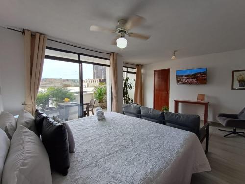 un soggiorno con letto bianco e divano di Cómodo apartamento en el centro de Granada a Cali