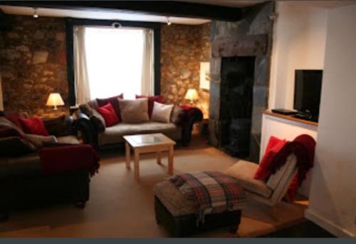 a living room with a couch and a fireplace at Stylish 4Bed Cottage with parking near town and beach in Lyme Regis