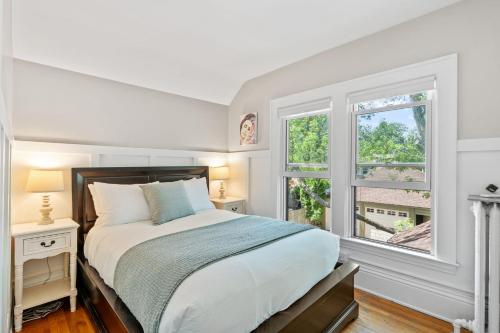 Un dormitorio blanco con una cama y dos ventanas. en Pillsbury Hideaway, en Minneapolis