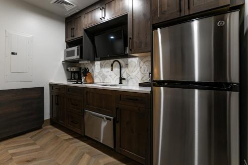 a kitchen with wooden cabinets and a stainless steel refrigerator at Condos at Canyons Resort by White Pines in Park City