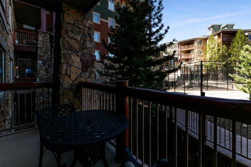 a patio with a table and a tree on a balcony at Condos at Canyons Resort by White Pines in Park City