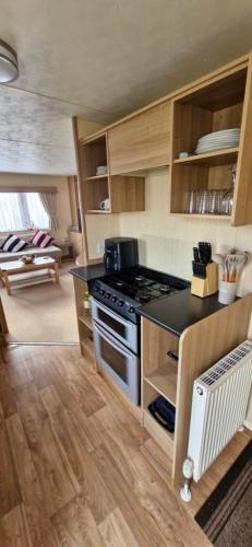a kitchen with a stove top oven in a room at MOLLIES DEN 3 8 Berth 3 bedroom Waterside Leisure Park INGOLDMELLS in Ingoldmells