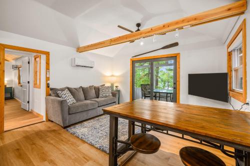 a living room with a table and a couch at Arbutus Lakeview Retreat I Fishing l Near TC! in Traverse City