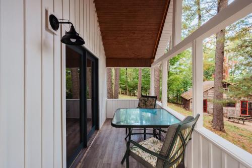 a screened porch with a glass table and chairs at Arbutus Lakeview Retreat I Fishing l Near TC! in Traverse City
