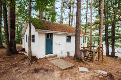 a small house with a blue door in the woods at Arbutus Lakeview Retreat I Fishing l Near TC! in Traverse City