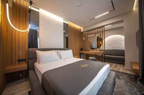 una habitación de hotel con una cama y un sofá en Noam Luxury Hotel, en Sarandë
