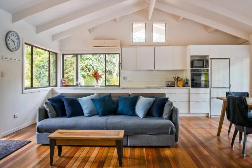 a living room with a couch and a kitchen at Snows Creek Retreat - The Pool House in Upper Coopers Creek