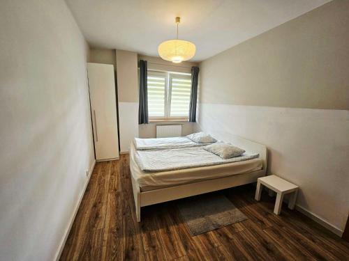 ein kleines Schlafzimmer mit einem Bett und einem Fenster in der Unterkunft Green Kabaty Apartment 5 in Warschau