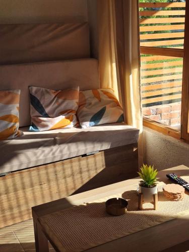 a bed sitting in a room next to a window at Vikendica Trenutak - Vikendica na Drini in Loznica