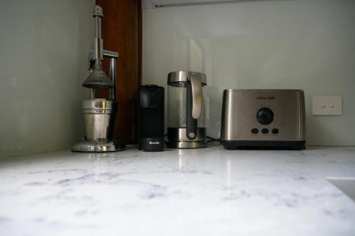 Una encimera de cocina con una cafetera y una tostadora. en Snows Creek Retreat - The Creek House, en Upper Coopers Creek