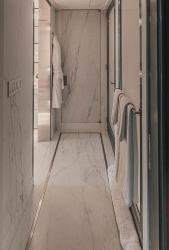 a bathroom with white marble walls and a walk in shower at Fasano Fifth Avenue I Private Members Club & Hotel in New York