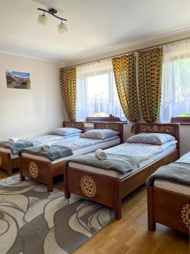 a bedroom with four beds in a room at Pokoje Gościnne u Wioli in Jurgów