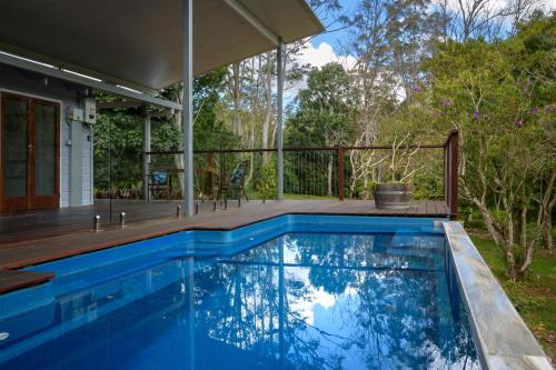 a swimming pool with a deck and a house at Snows Creek Retreat - The Pool House in Upper Coopers Creek
