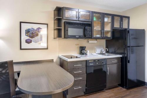 a kitchen with a table and a black refrigerator at Executive Residency by Best Western Philadelphia-Willow Grove in Horsham
