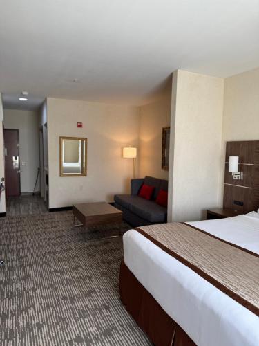 a hotel room with a bed and a couch at Evergreen Inn & Suites in Monroe