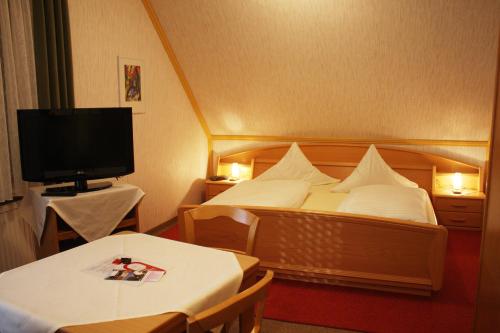 a hotel room with two beds and a television at Hotel Drei Kronen in Burgkunstadt