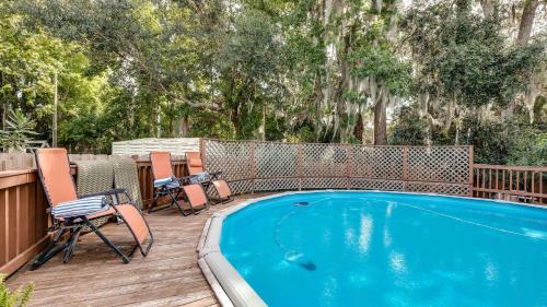 a swimming pool on a deck with chairs and a fence at Backyard Pool! Refresh at Rivermist Condo in Savannah