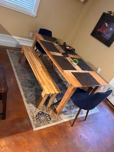a wooden dining table with a blue chair and a table at Backyard Pool! Refresh at Rivermist Condo in Savannah