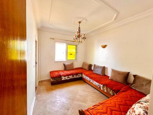 a living room with a red couch and a window at Palm beach in Mansouria in O Ben Slimane