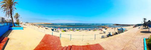 a beach with a crowd of people and the ocean at Palm beach in Mansouria in O Ben Slimane