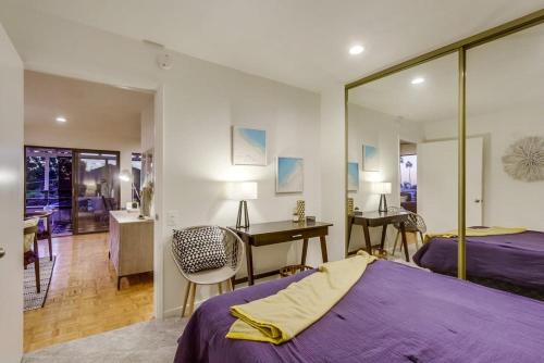 a bedroom with a purple bed and a desk at Beryl Bungalow in San Diego