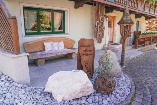 a house with a bed and a bench and rocks at Apartments Wiglhof in Jenbach