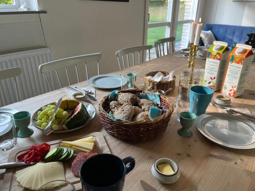 a table with baskets of food and cheese on it at Jensens B&B in Egtved