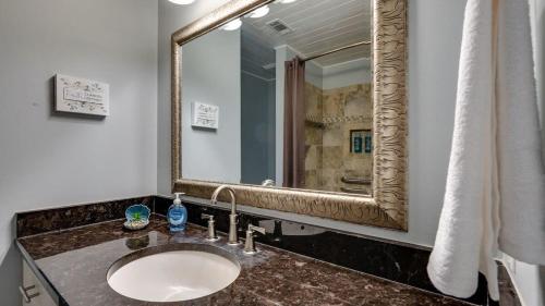 a bathroom with a sink and a large mirror at Year-Round Pool & Backyard Near Tybee Island in Savannah